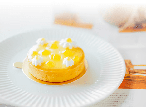 A vibrant lemon tart, showcasing high-quality egg products, topped with glossy yellow jelly and delicate white cream.