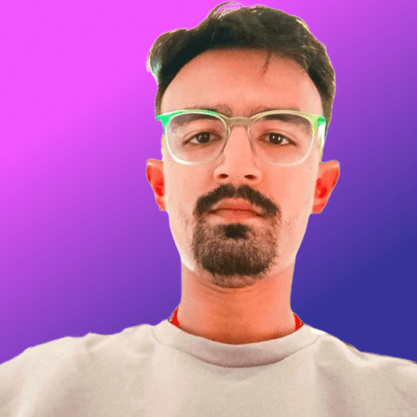 a man in a pink shirt looking at the camera