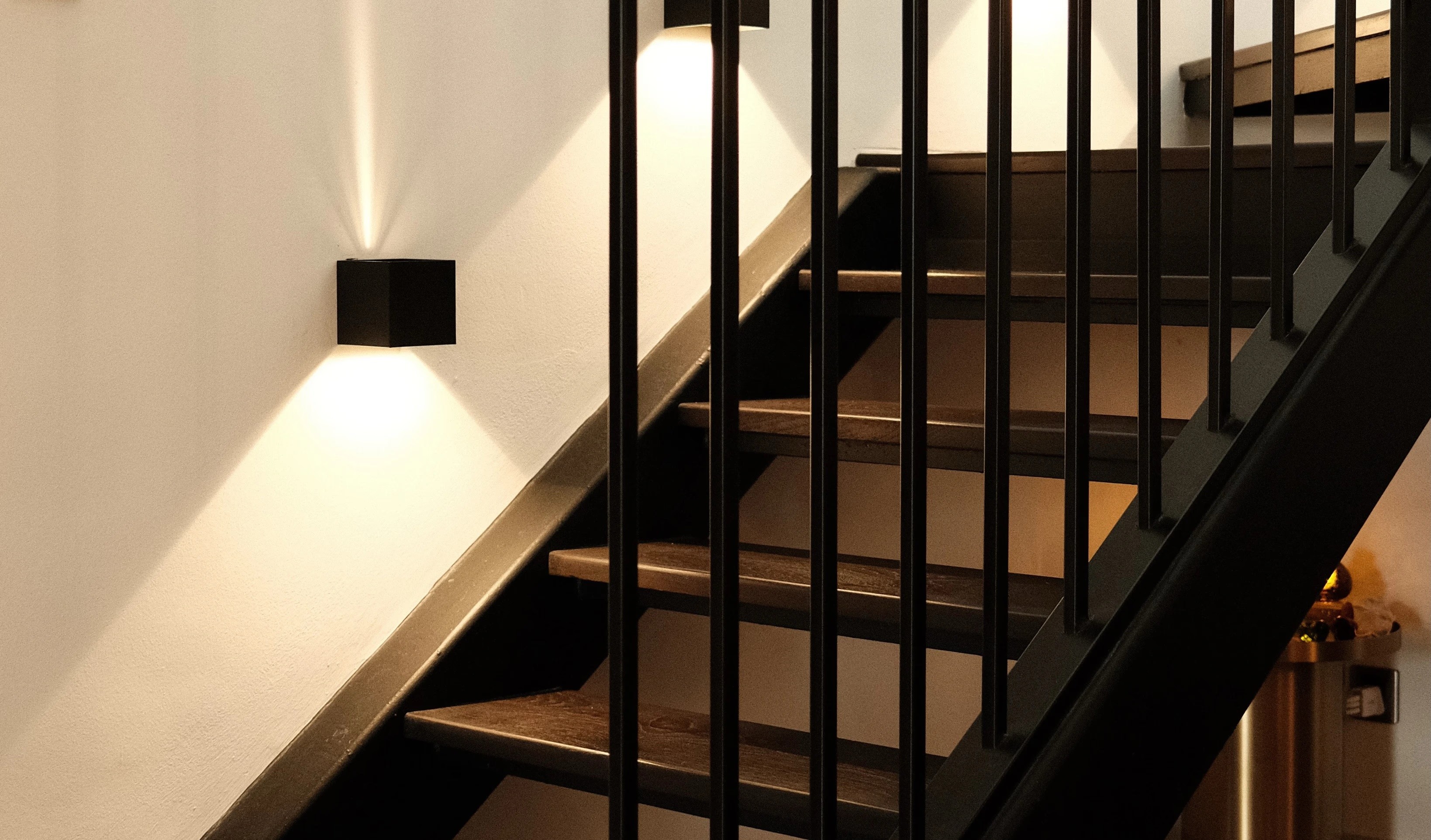 Industrial-style staircase with black metal railing and pendant light, HDB maisonette renovation Singapore
