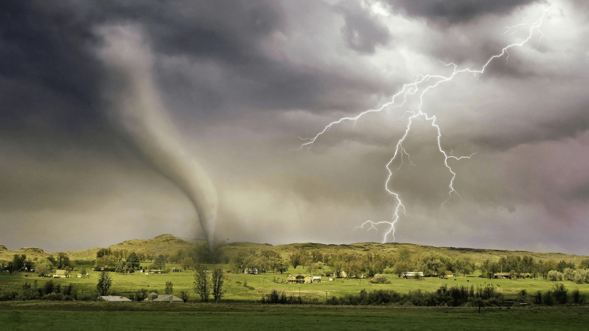 A tornado forming under storm clouds, capturing extreme fluid dynamics phenomena occurring in nature