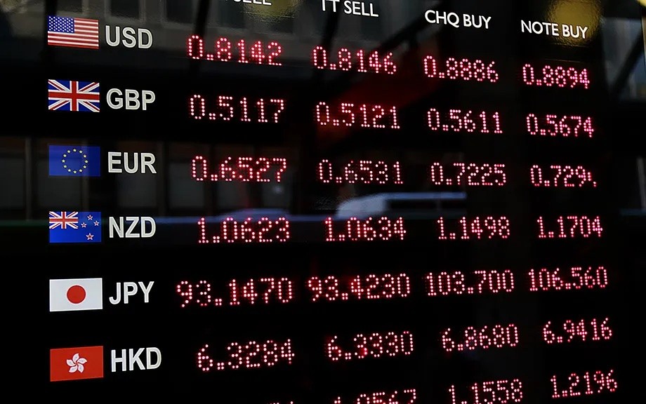 Wechselkurstafel mit Ankaufs- und Verkaufskursen für USD, GBP, EUR, NZD, JPY und HKD in roten Digitalziffern.