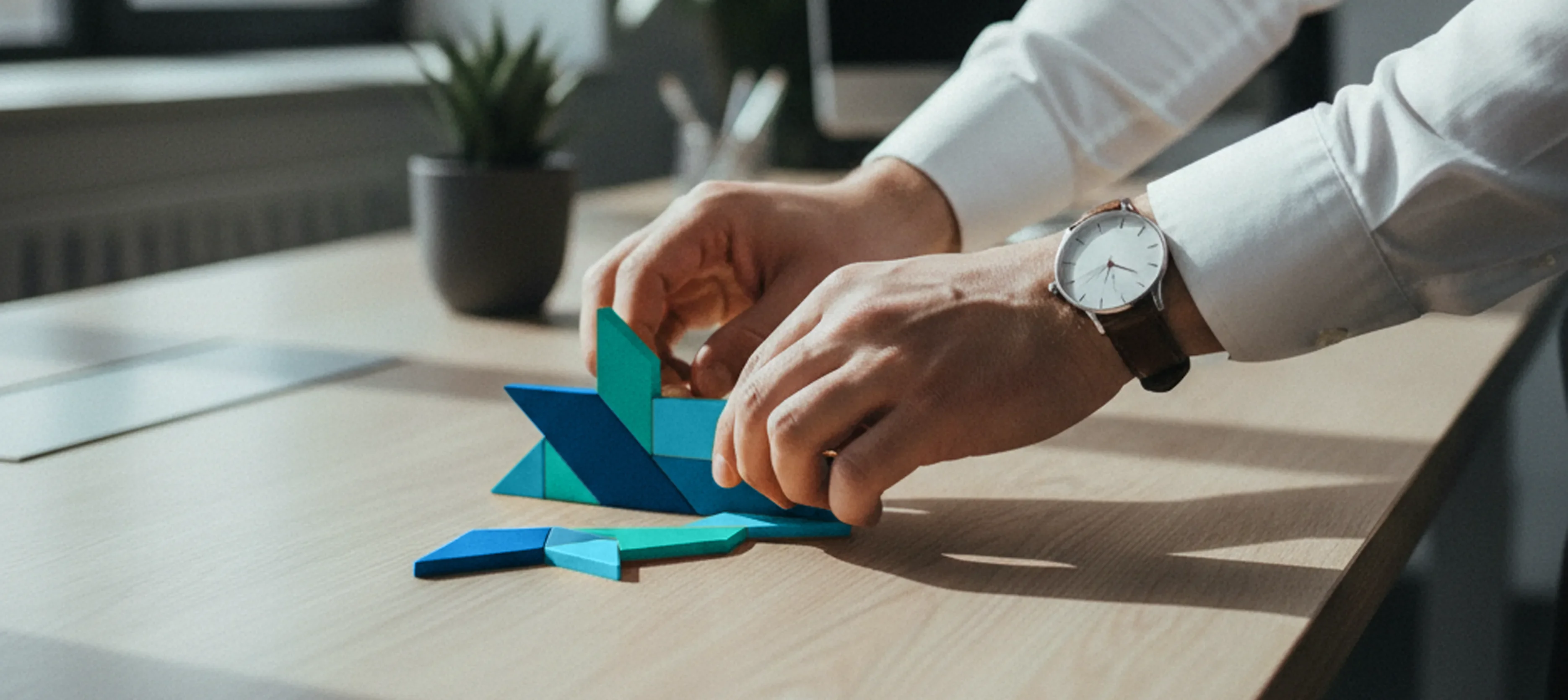 Method Consultants visual identity application – hands assembling turquoise and blue Tangram pieces representing adaptability and infinite possibilities by Teatime Studio.
