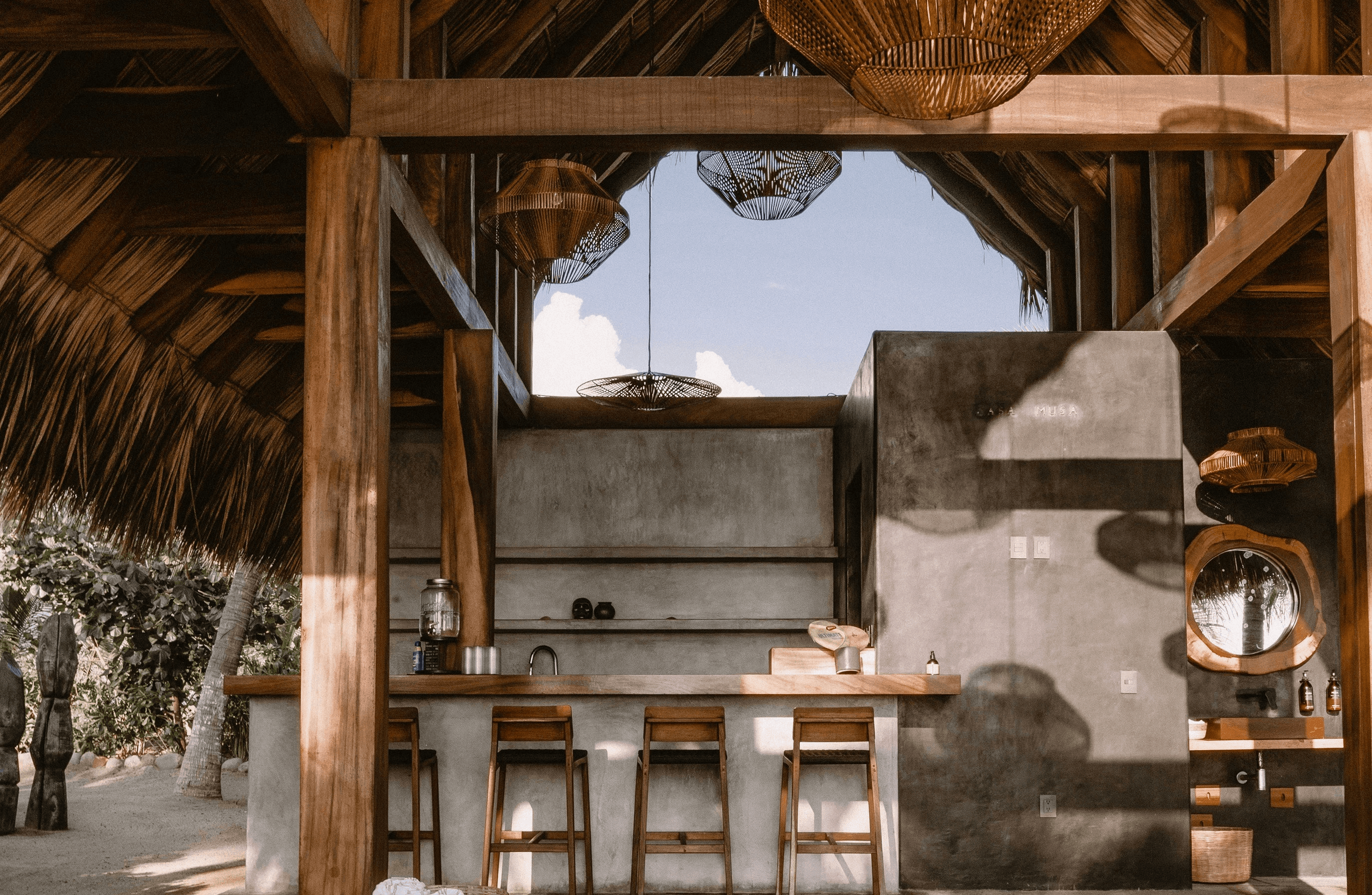 a living room filled with furniture under a wooden roof