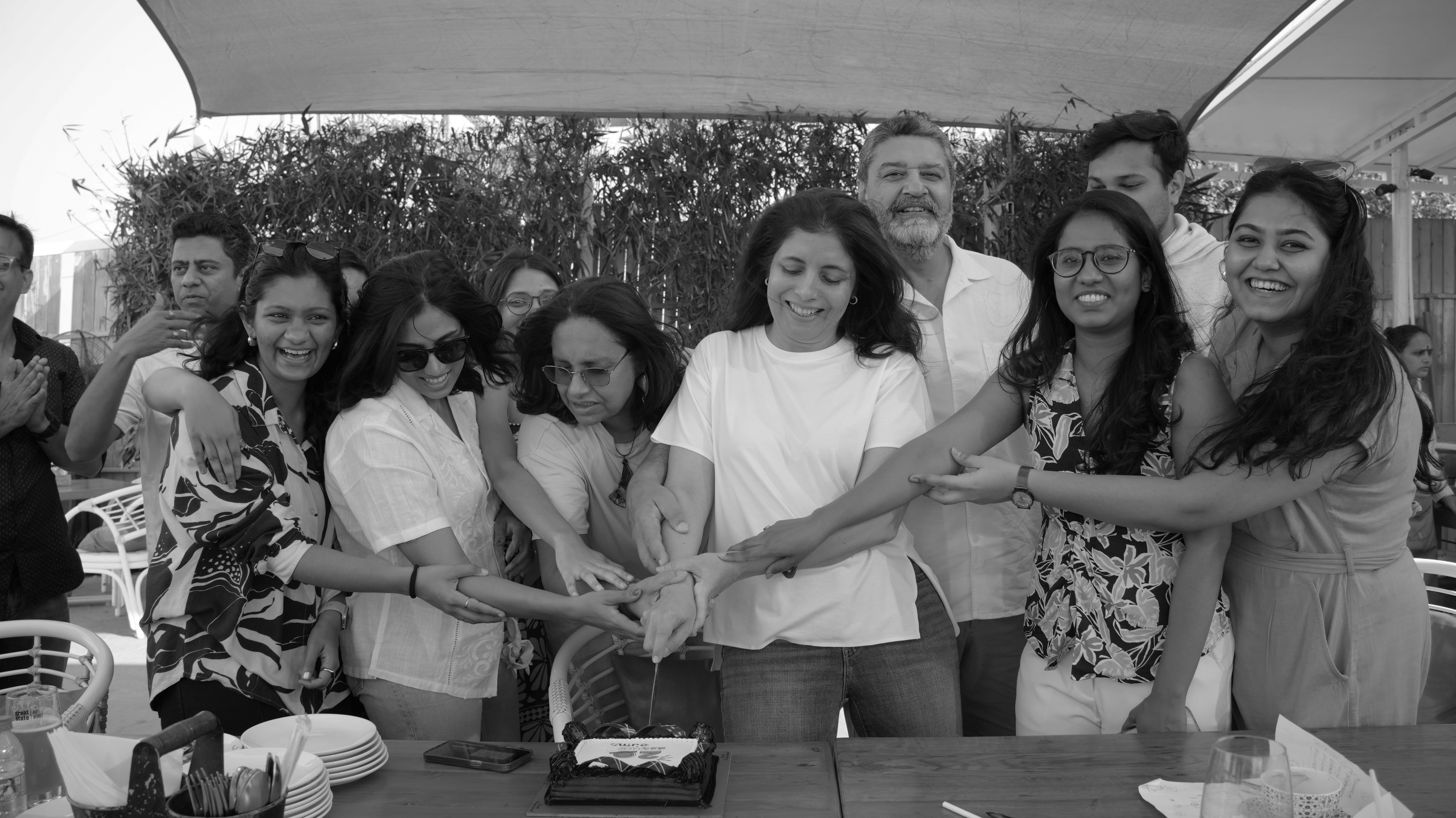 A silhouette of a person wearing sunglasses, with tousled hair, against a teal background.