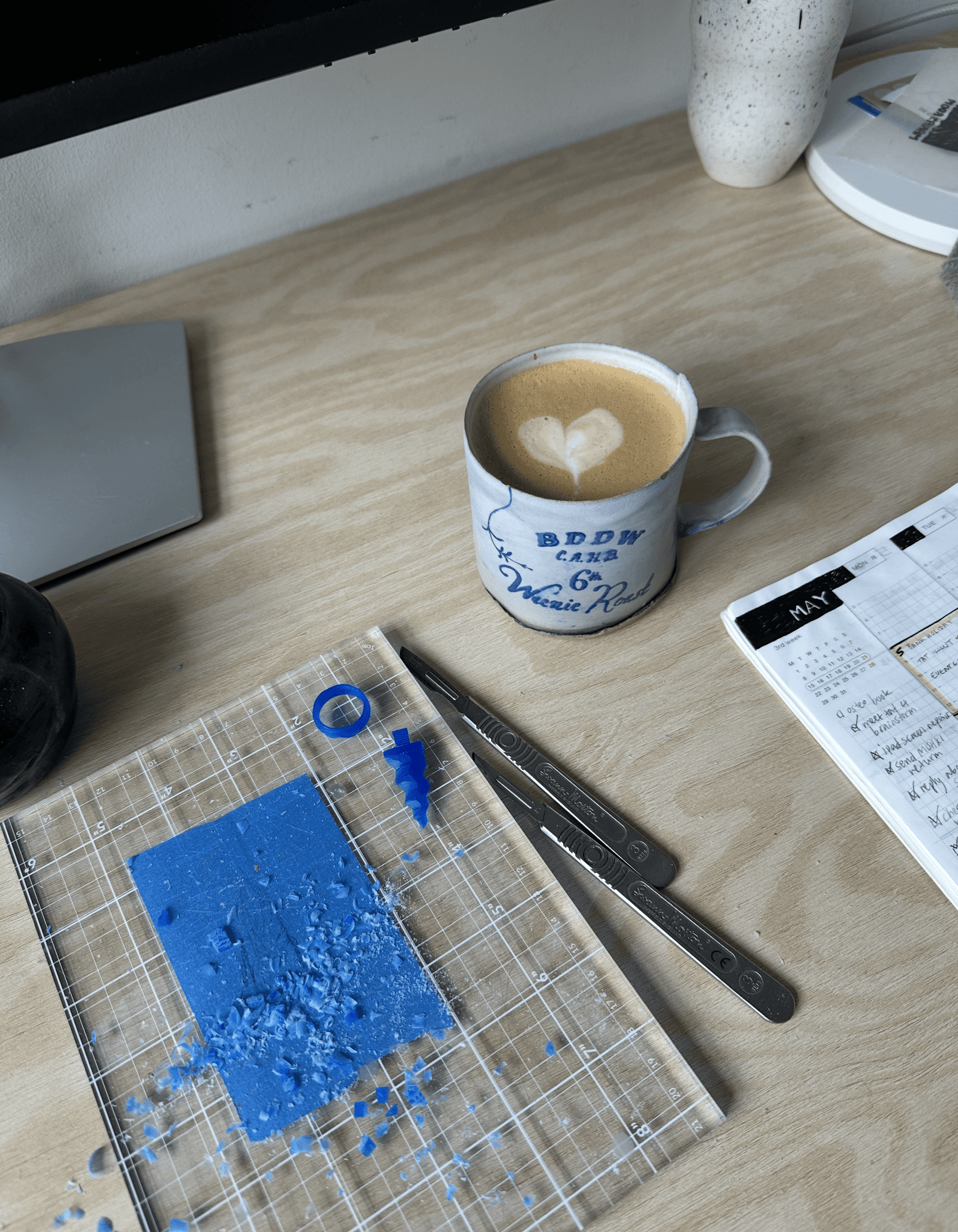 A view of a studio interior with modern decor, featuring large windows that offer a glimpse of lush greenery outside