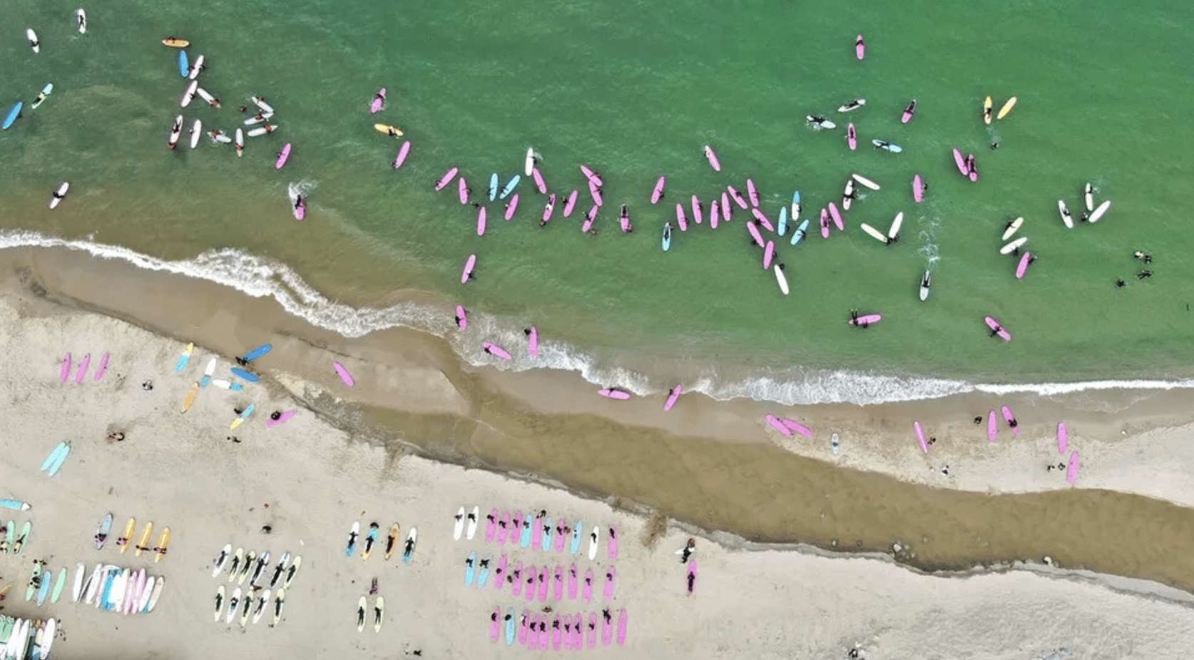 A cozy workspace featuring a wooden desk, a lamp, books, and a plant, illuminated by warm sunlight.