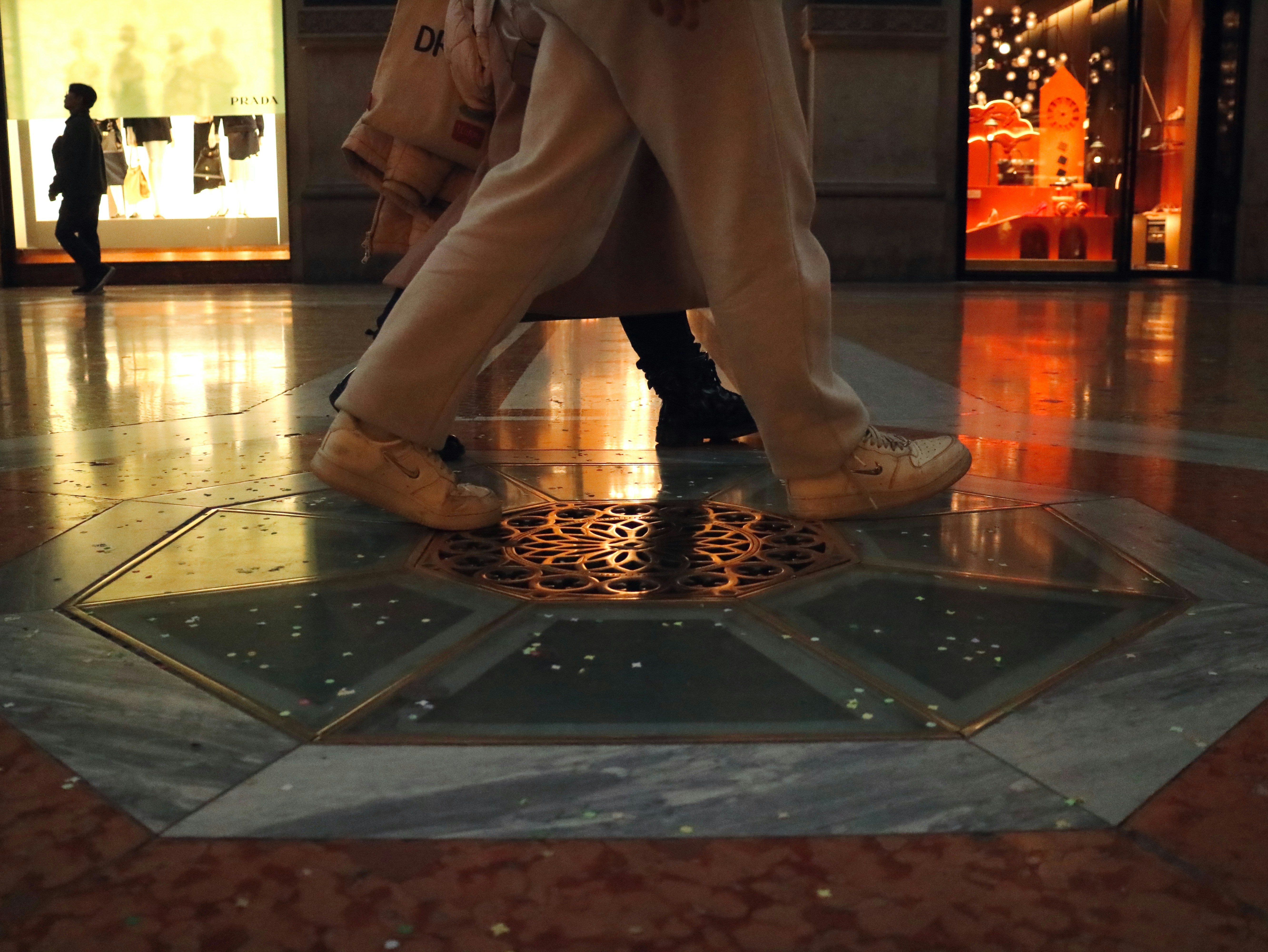 People walking on a polished marble floor.