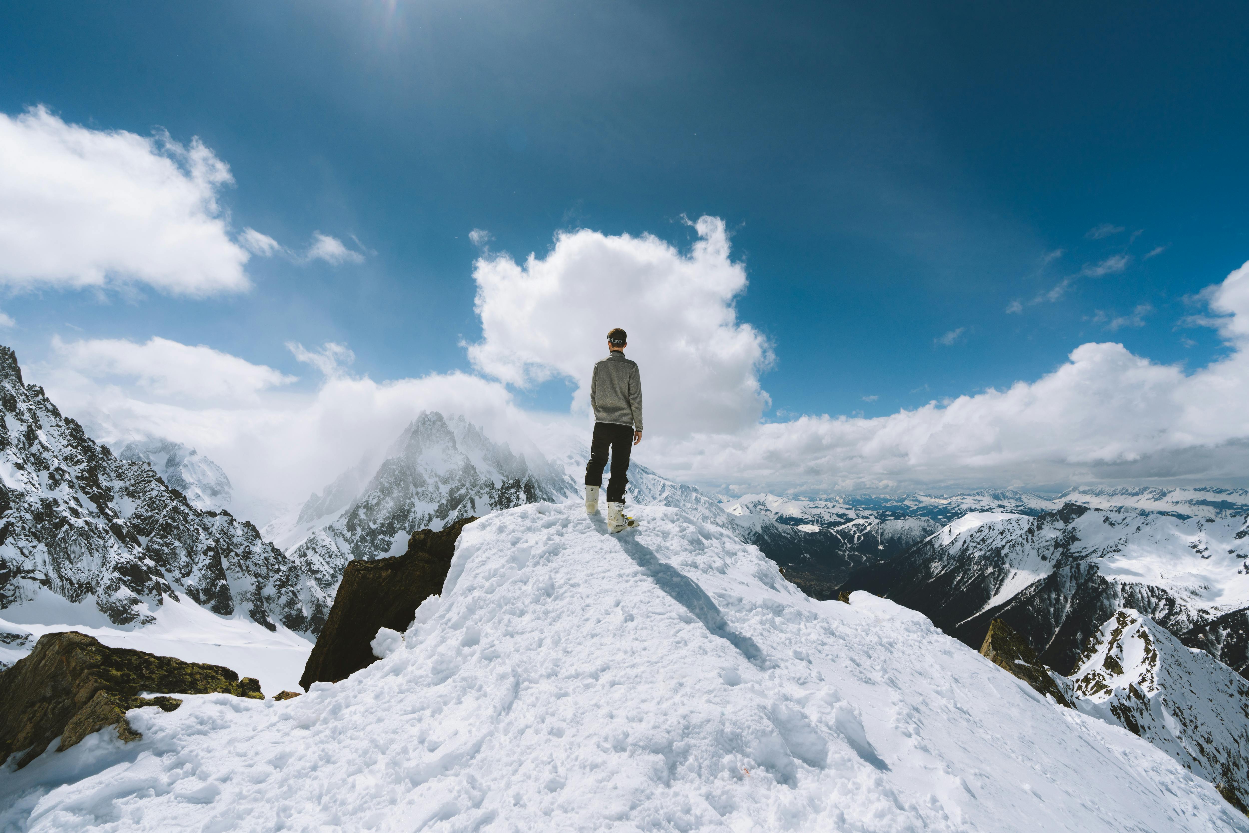 a woman on the top of a snow-capped mountain