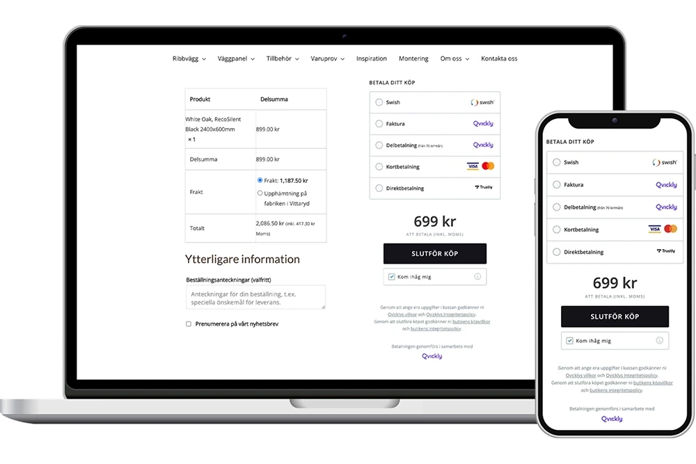 A young person with curly hair smiles at the camera while sitting in front of a laptop against a dark background.