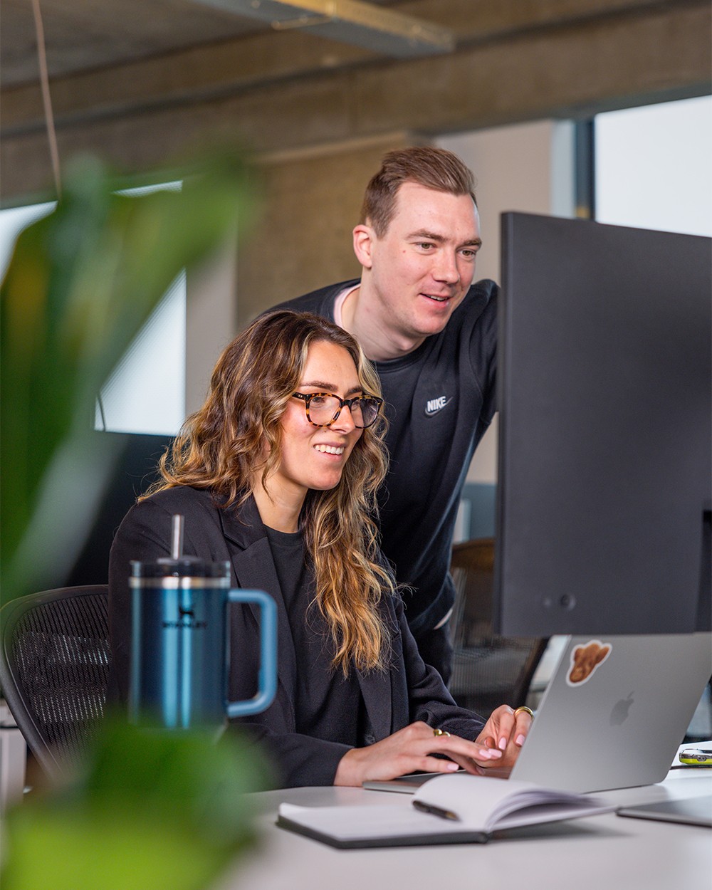 Two people looking at a computer screen in an office