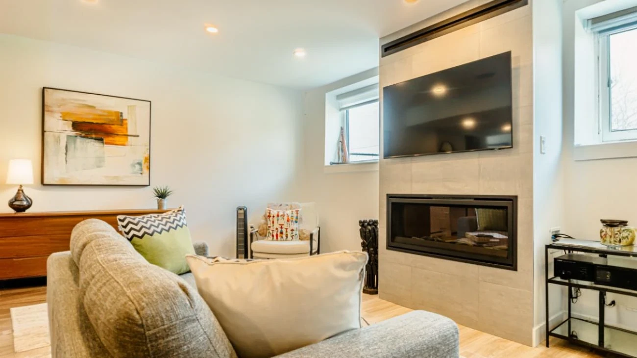 Cozy living room with modern fireplace, flat-screen TV, and comfortable seating in Burnaby home by Vancouver Custom Homes