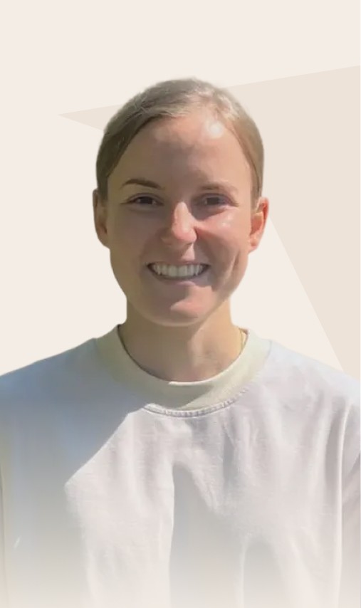 Portrait d'une femme portant un t-shirt blanc et souriant à la caméra.