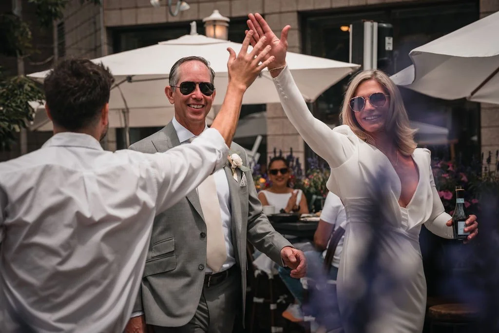 Bride dancing and reaching toward a guest at the reception