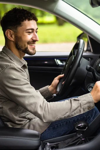 Homme souriant au volant après avoir récupéré son permis de conduire grâce à un accompagnement juridique spécialisé