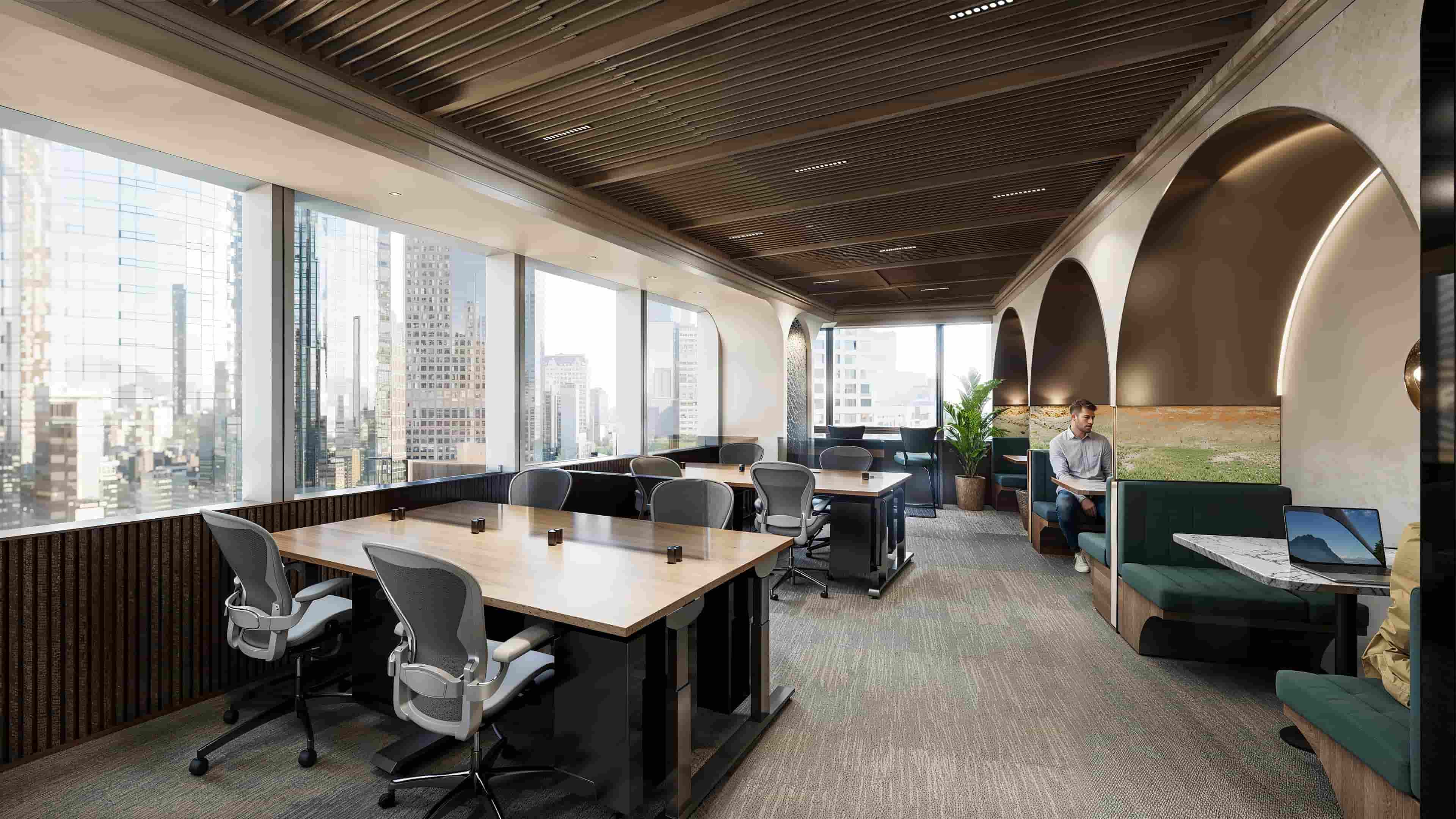 Modern workspace with shared desks, lounge seating and Riyadh skyline views 