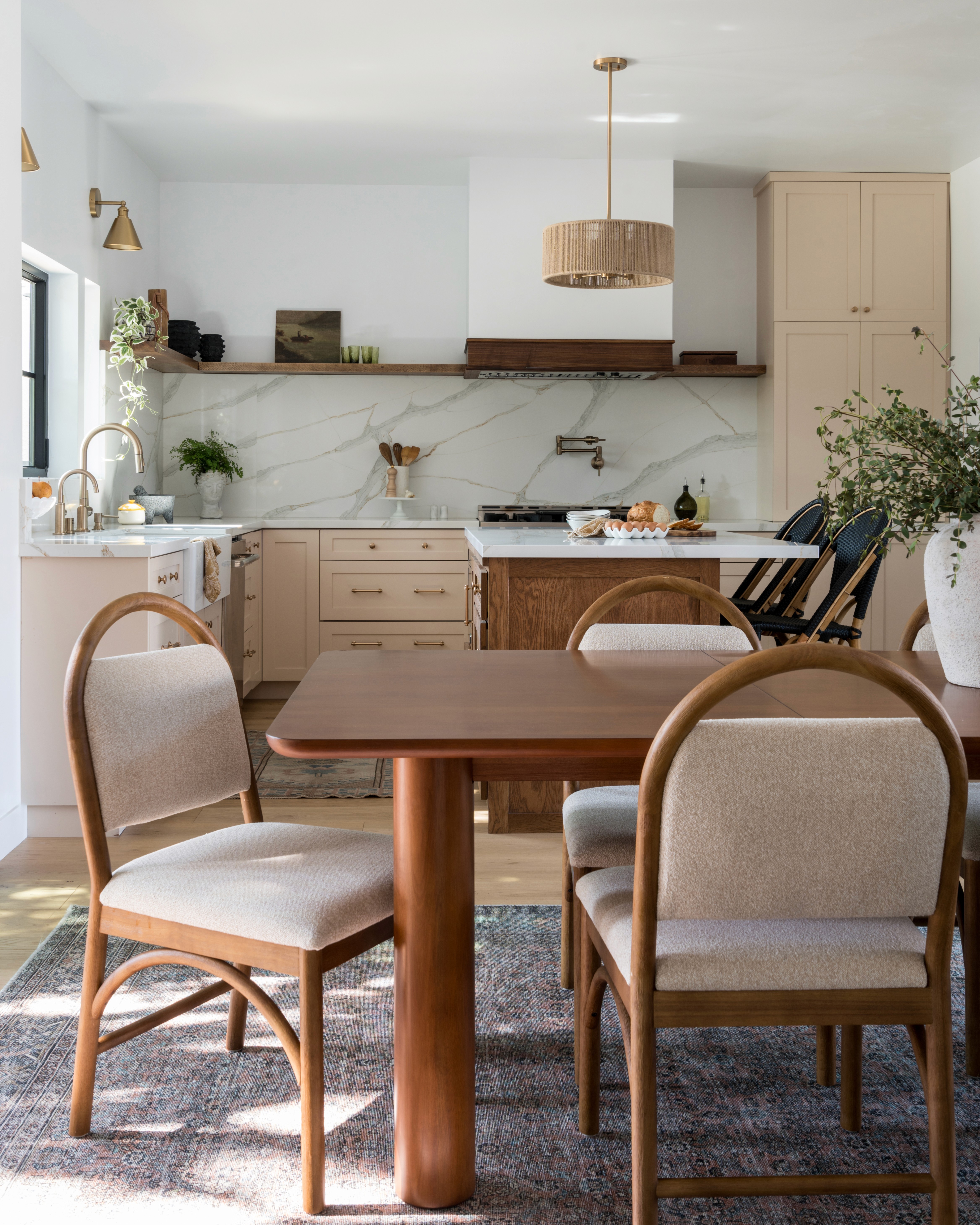 A bright and feminine kitchen featuring white countertops, soft pastel accents, and modern cabinetry. The space is designed with clean lines, a central island for gathering, and plenty of light, creating an inviting atmosphere by Jubilee Interiors in Lakewood, California
