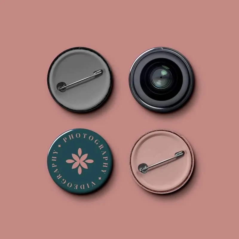 Daisy & Lily Photography branded enamel pins arranged on a pink background