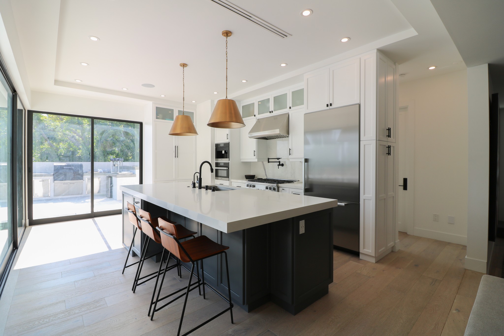Custom kitchen cabinets made with shaker doors, island, and black hardware