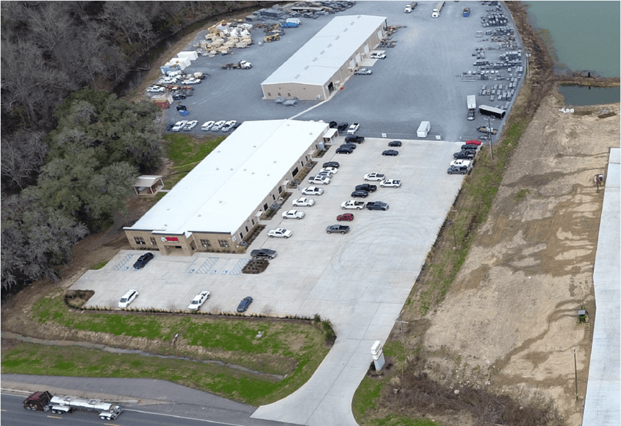 Aerial view of the Apache Industrial site showing the main building, paved lot, and rear storage area.