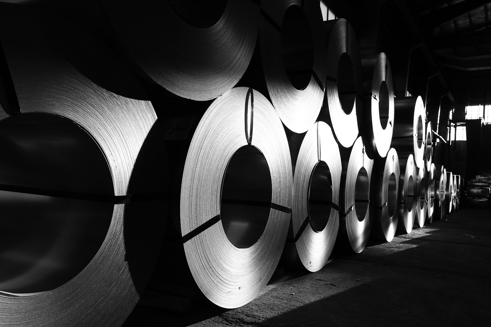 Rows of steel master coils lined up in a metal service center warehouse