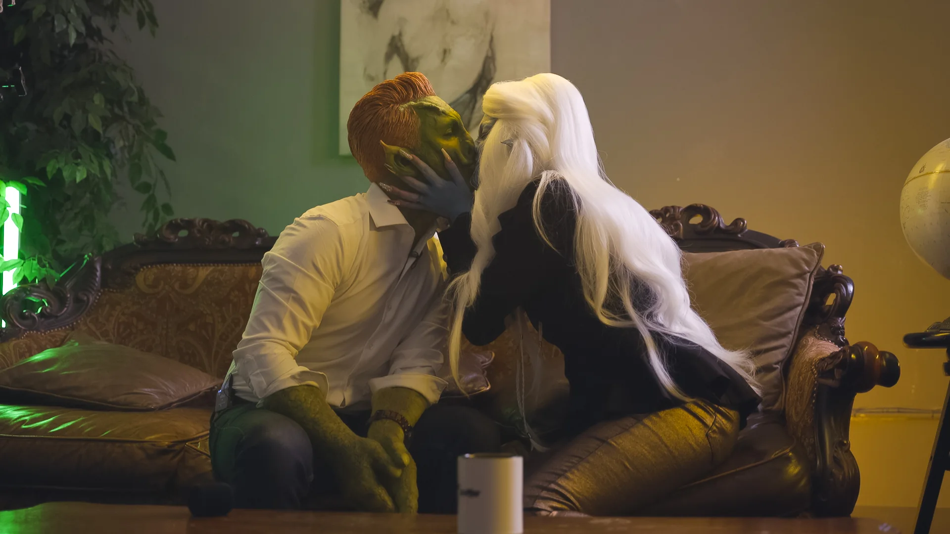 Two Desk/Show monster characters sharing a darkly comic couch moment