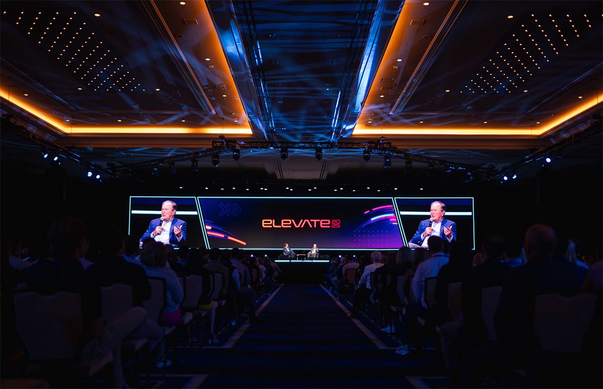 The Envestnet Elevate 2025 main stage with an advisor keynote speaker seated at the center, speaking into a microphone