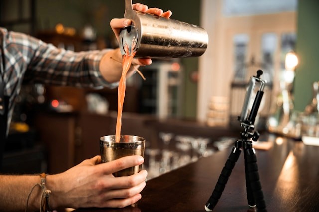 Pouring a cocktail from one shaker tin into another