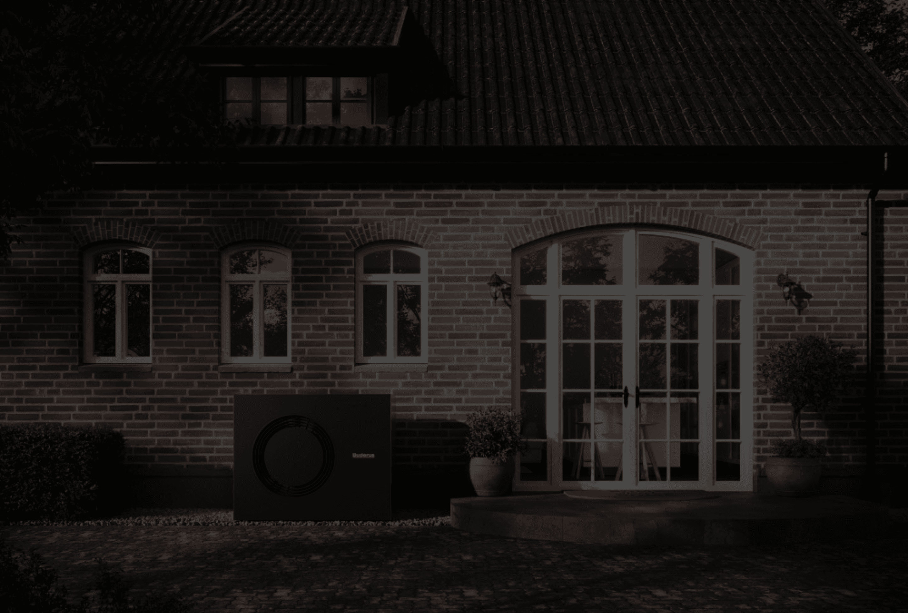 Moderne Luft-Wasser-Wärmepumpe vor einem sanierten Altbau mit roter Klinkerfassade und weißen Fenstern. Die Anlage zeigt, wie sich Wärmepumpen harmonisch in bestehende Gebäude integrieren lassen und energieeffizientes Heizen im Altbau ermöglichen.