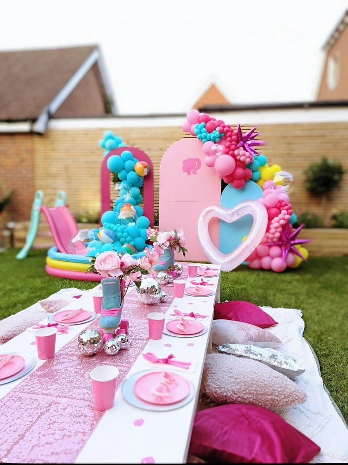 Bright pink kids party with heart balloons, themed props and coordinated table setup