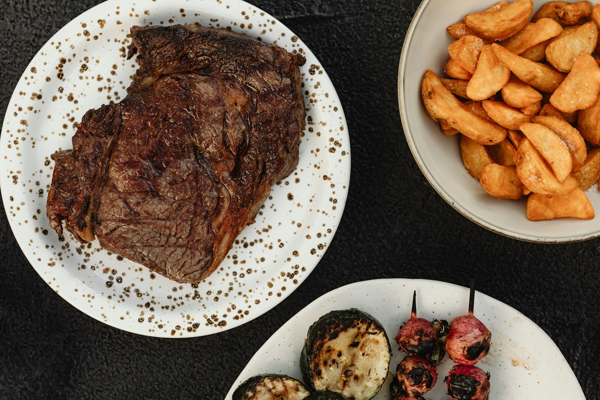 Grilled steak served with roasted potato wedges and grilled vegetables at a restaurant in Reykjavík.