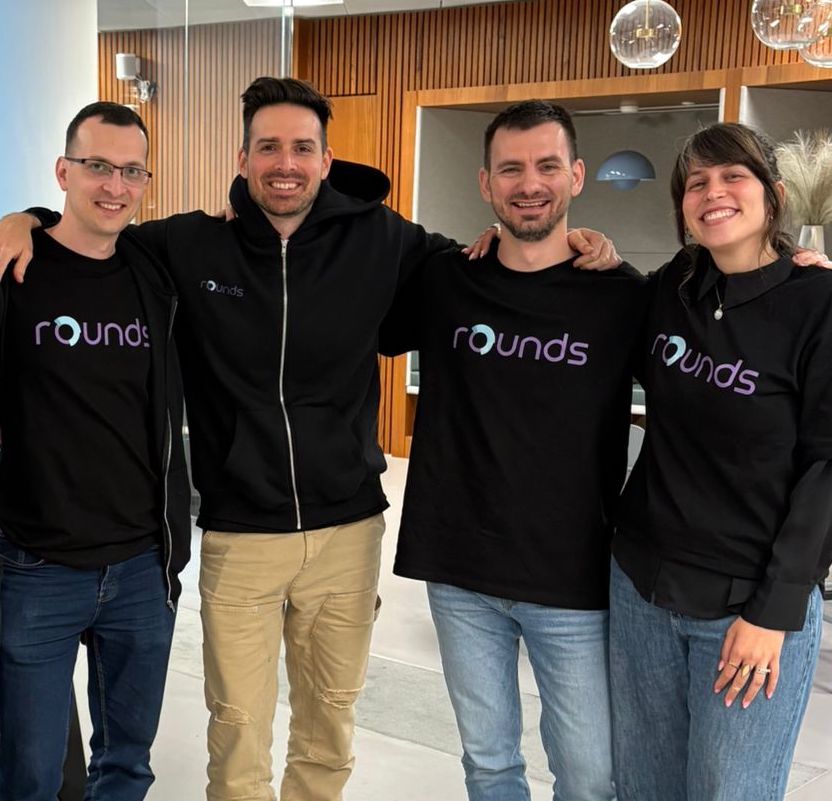 Diverse team celebrating success at office desk.