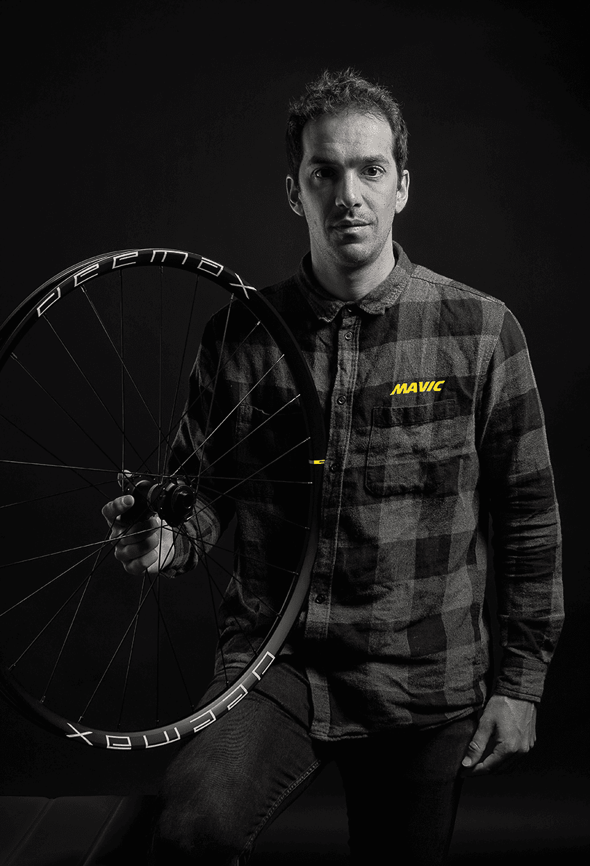 Portrait  professionnel N&B  homme avec roue vélo à la main studio fond noir 
