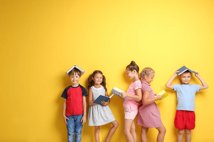 a group of children standing in front of a bright yellow wall