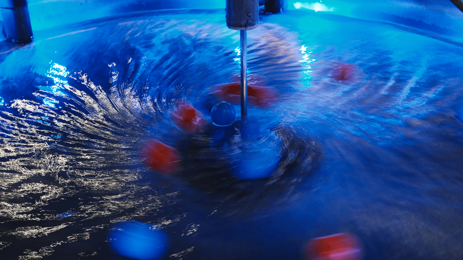 Different colored balls move in circles in the vortex pool.