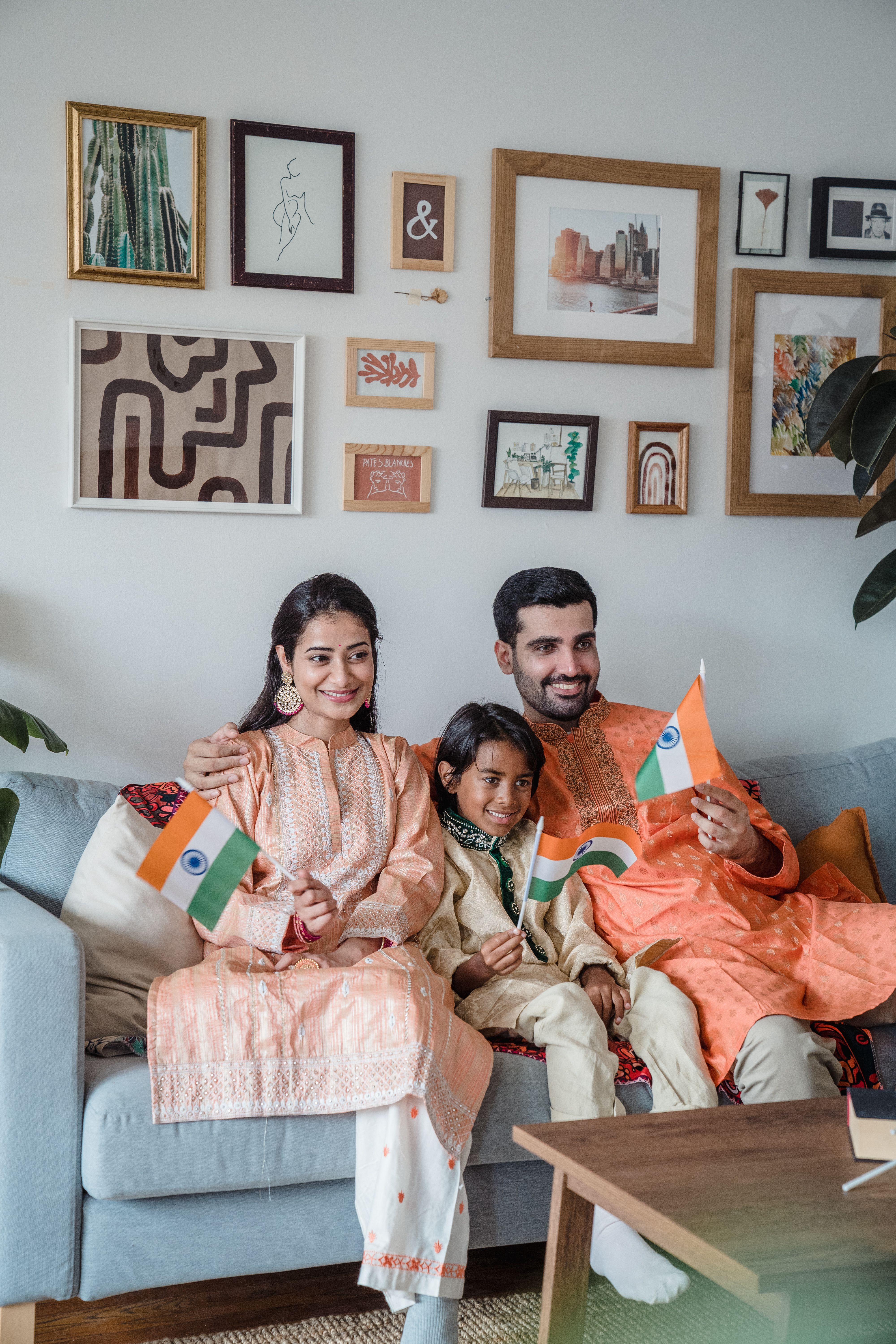 family-in-traditional-clothing-celebrating-with-indian-flags-on-a-sofa-at-home. - anna-pou (pexels)