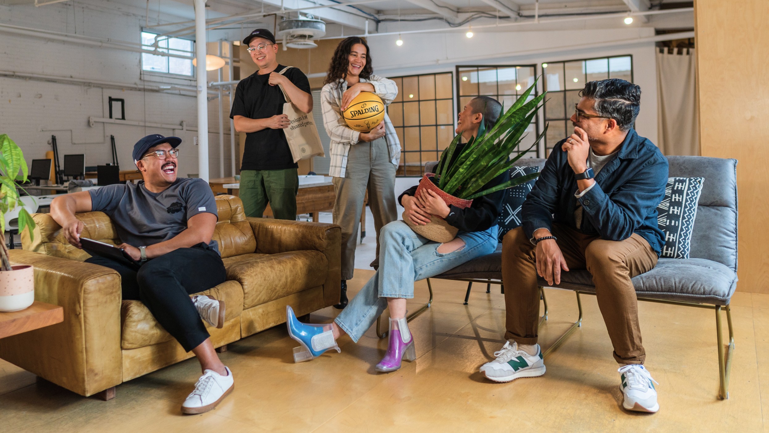 A photo of a diverse group of individuals sitting, smiling and looking at one another.