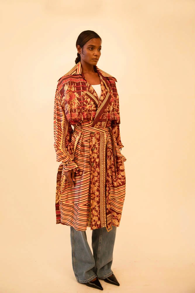Rust-colored silk trench coat crafted from vintage fabric, featuring a relaxed fit, self-tie belt, and no inner lining, celebrating lightweight layering and conscious design.