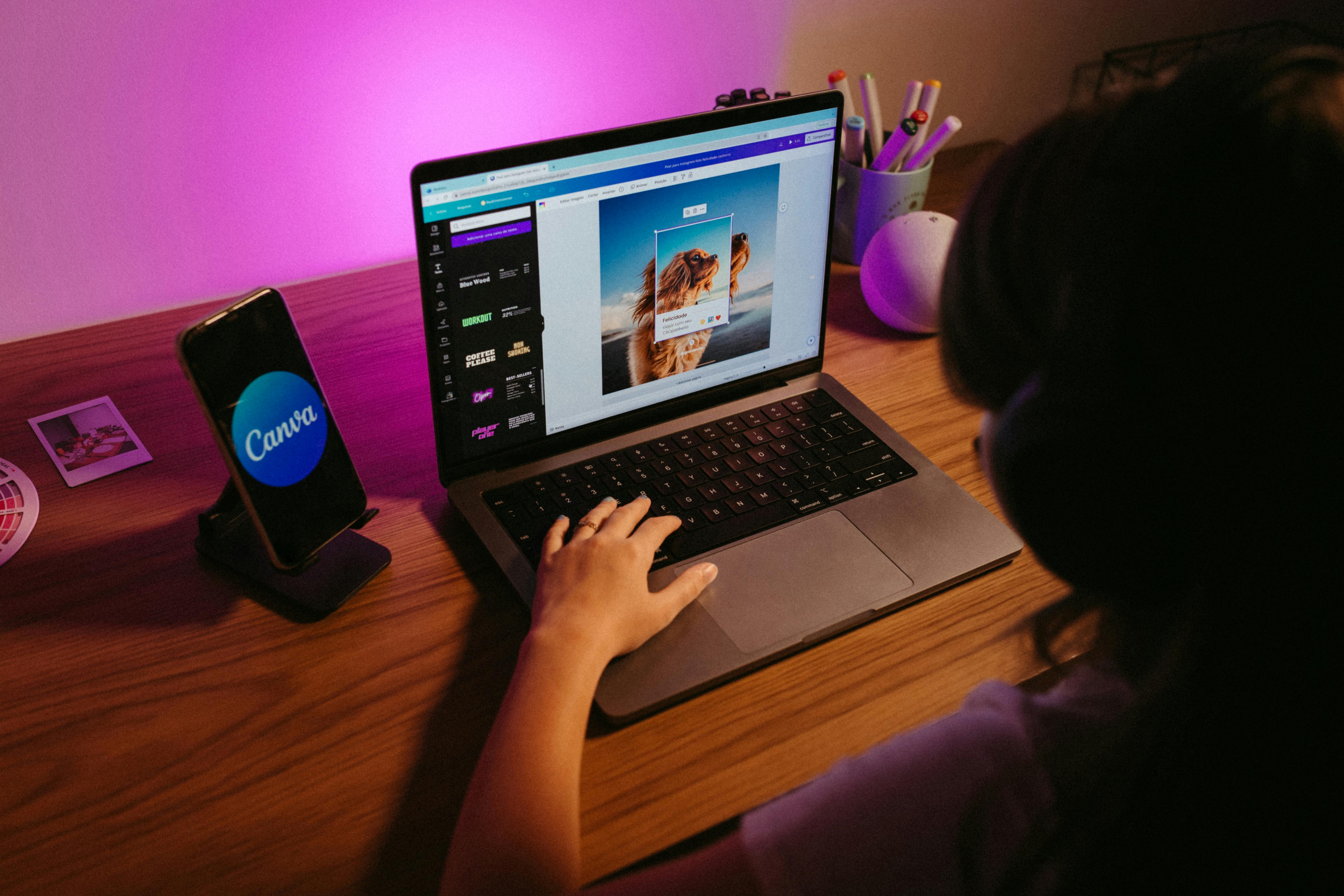Une personne est sur son ordi en train d'utiliser Canva