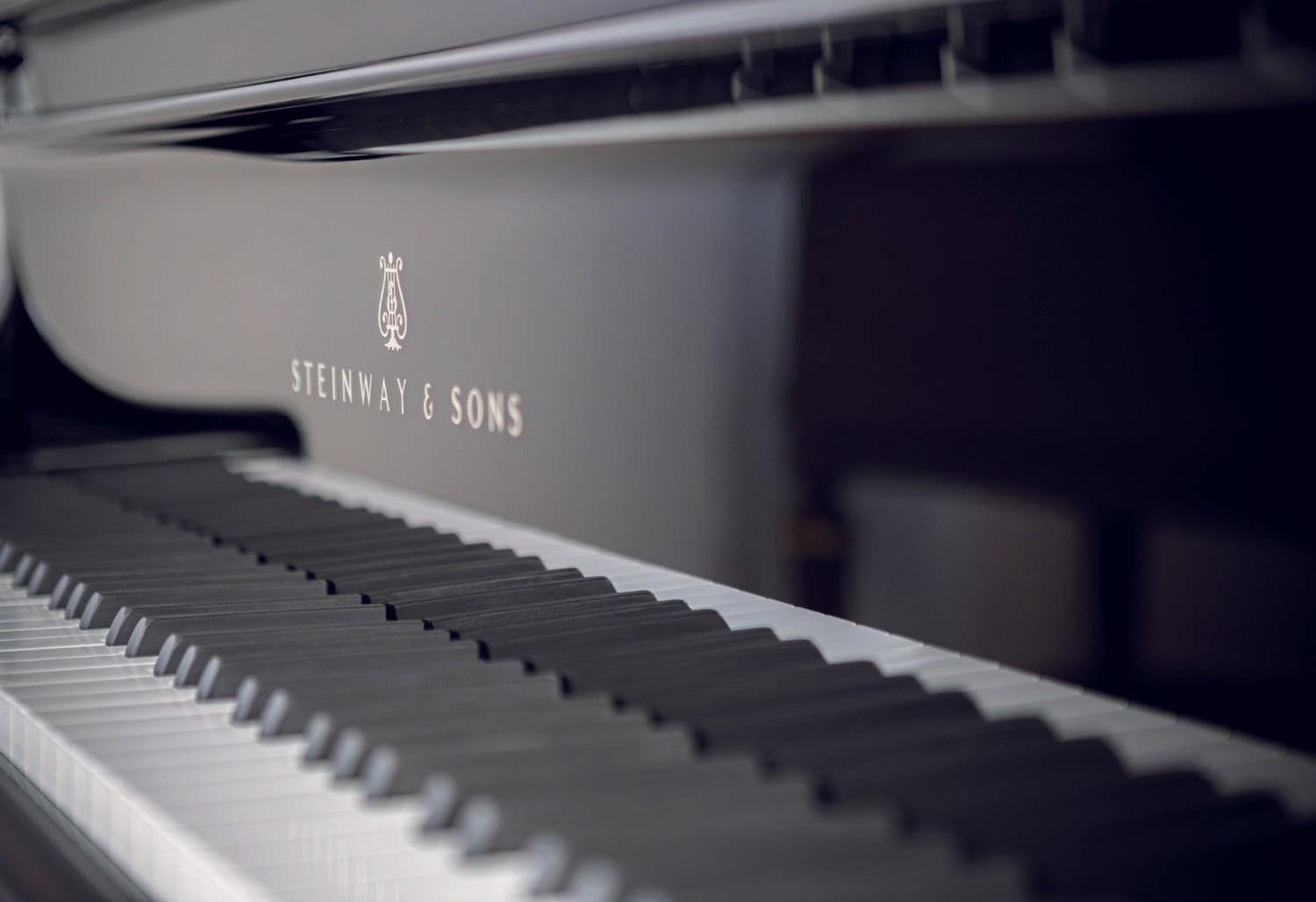 A close-up of the keyboard and logo of the Teague Model, displaying fine craftsmanship and glossy black finish.