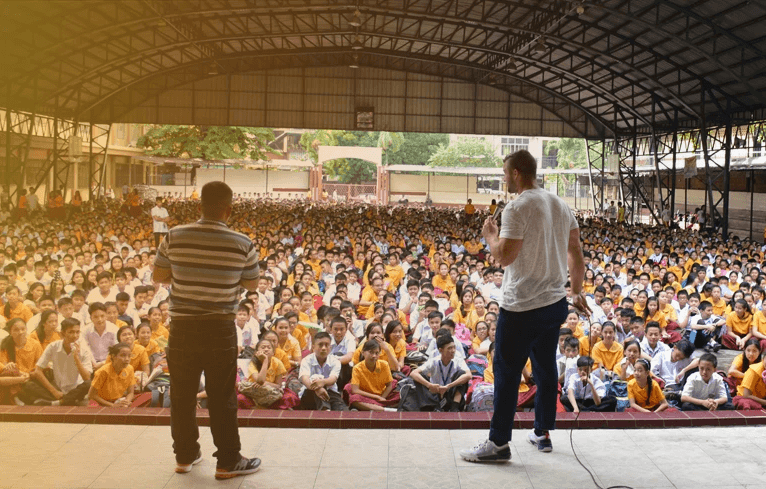a school of children in the philippines raising their hands