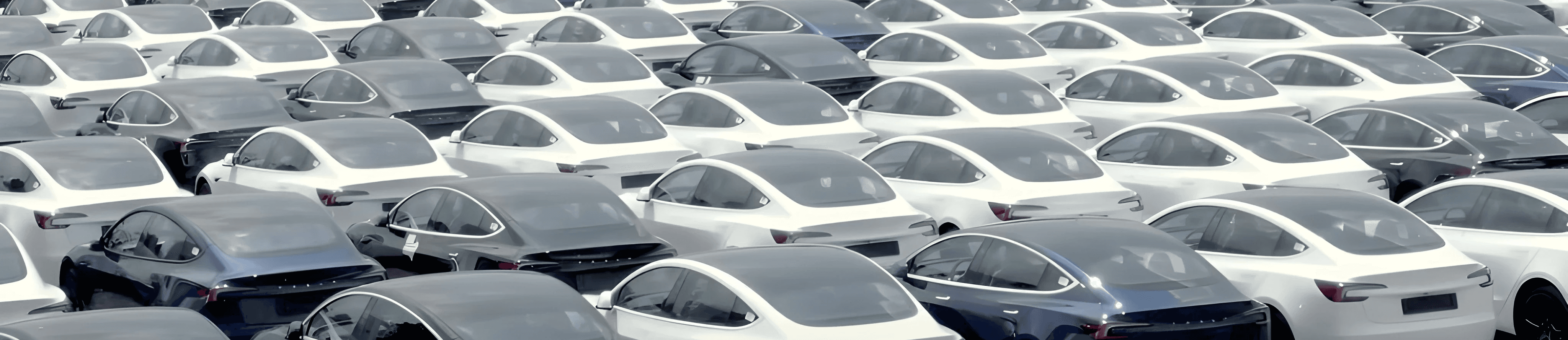 Tesla Model 3 en grand nombre sur un parking de stockage, aperçu d’un important stock de voitures électriques