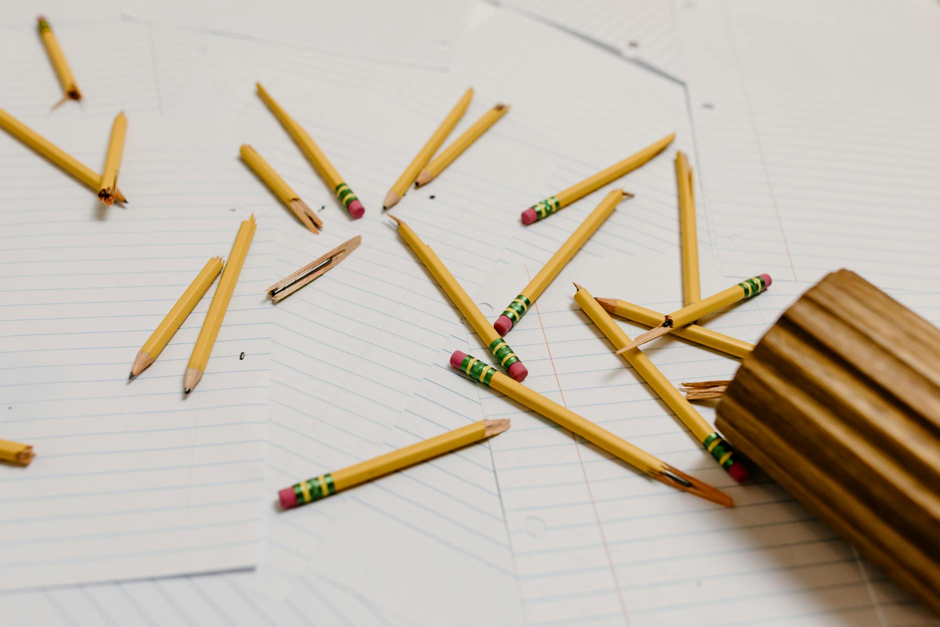 A frustrated teacher looking at a complex spreadsheet of data while sitting at a cluttered wooden desk.