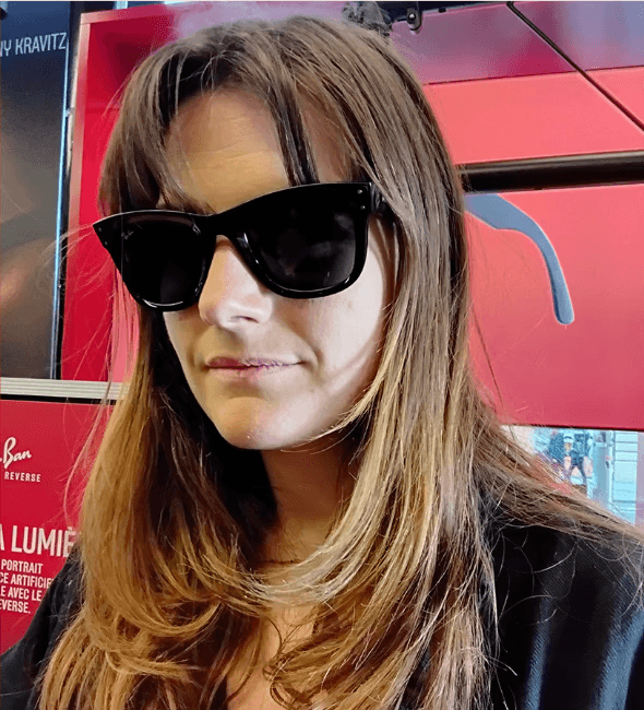 Customer posing with Ray-Ban REVERSE Wayfarer sunglasses in a shop.