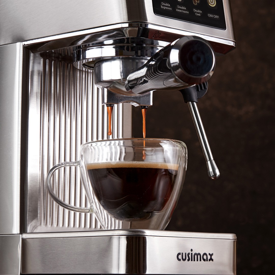 A sleek, stainless steel Cusimax espresso machine is brewing a rich, dark espresso into a transparent glass cup, with two streams of coffee pouring smoothly, highlighting its modern design and functionality.