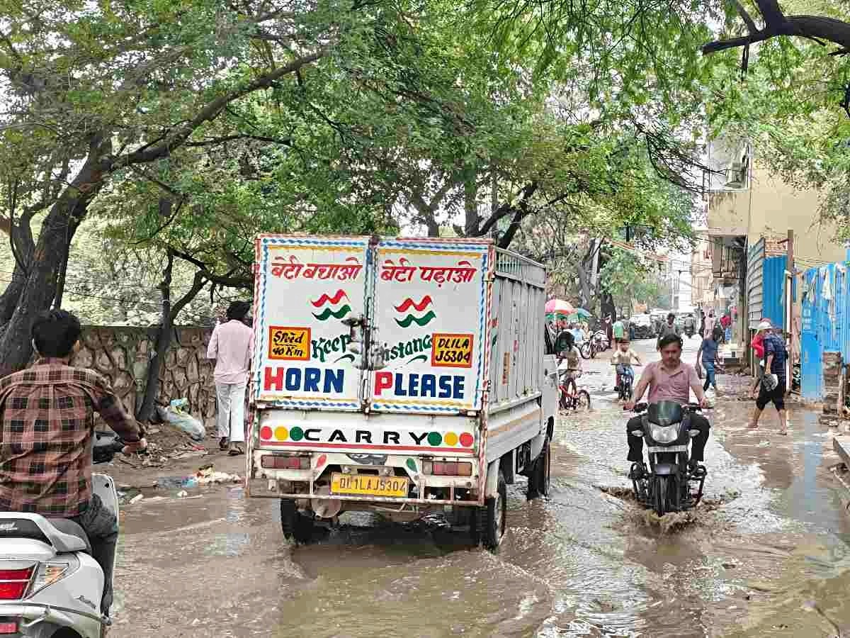 Vehicles pass through a waterlogged road in Hargovind Enclave, Chhattarpur, Delhi.