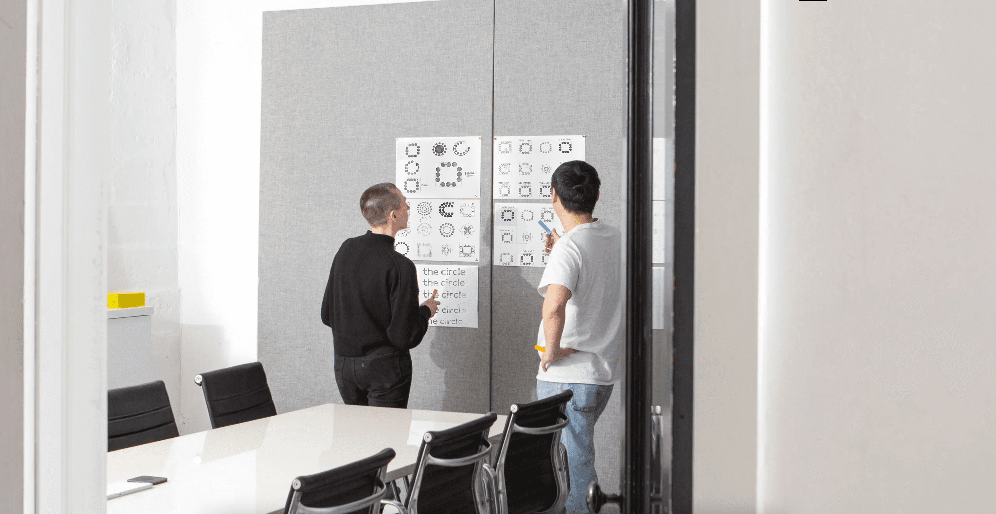 Monochrome product shot: black-capped cosmetic bottle with dynamic water splash on a clean white background.