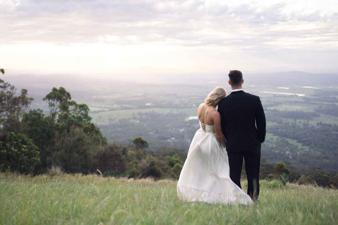 Bride and groom looking into the distance at sunset