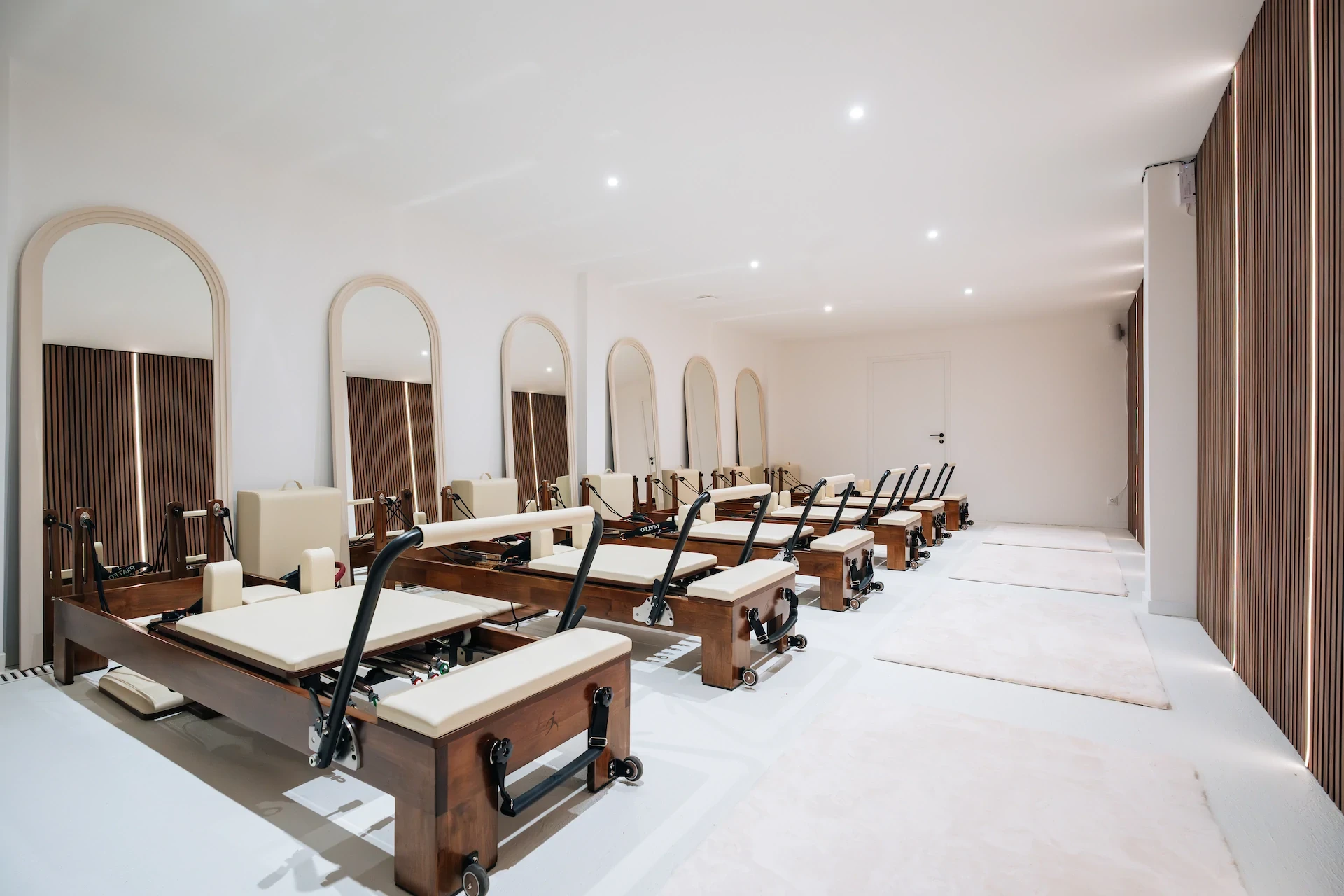 Salle de Pilates avec machines et miroirs. Equipement de fitness pour exercices de renforcement musculaire.