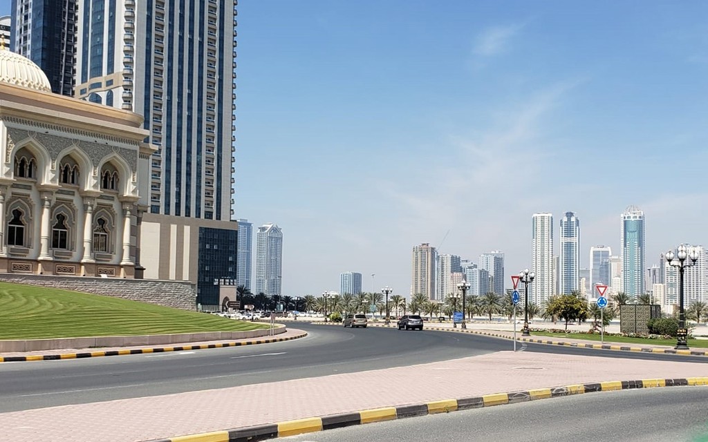 A street scene featuring a large building in the background, identified as Al Taawun.