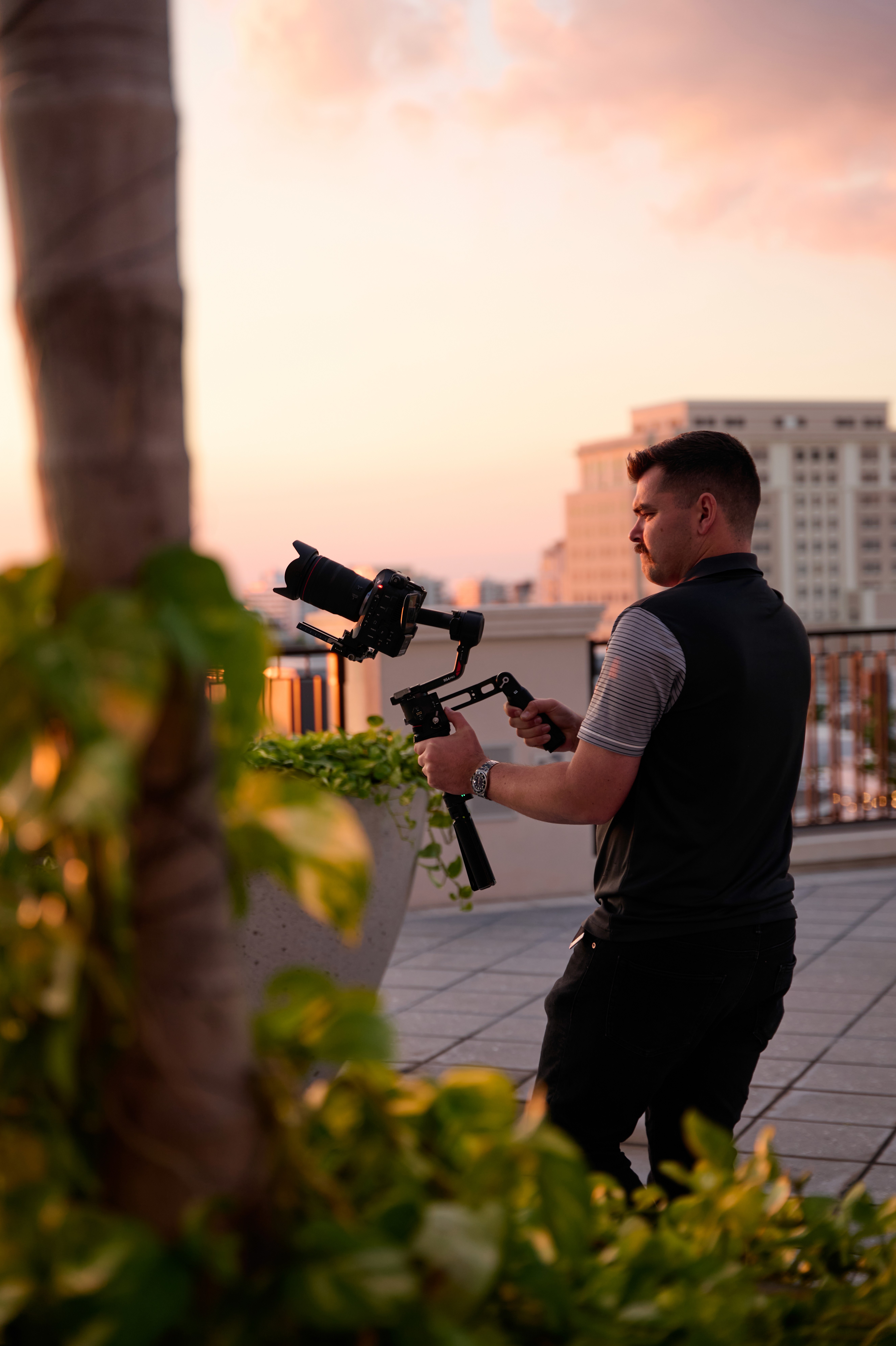 Alt text: A neatly arranged designer's kit featuring two textured fabric swatches in warm autumn colors, paint samples, two bottles, and a brush in a divided wooden box. The composition and tones evoke creativity and warmth.